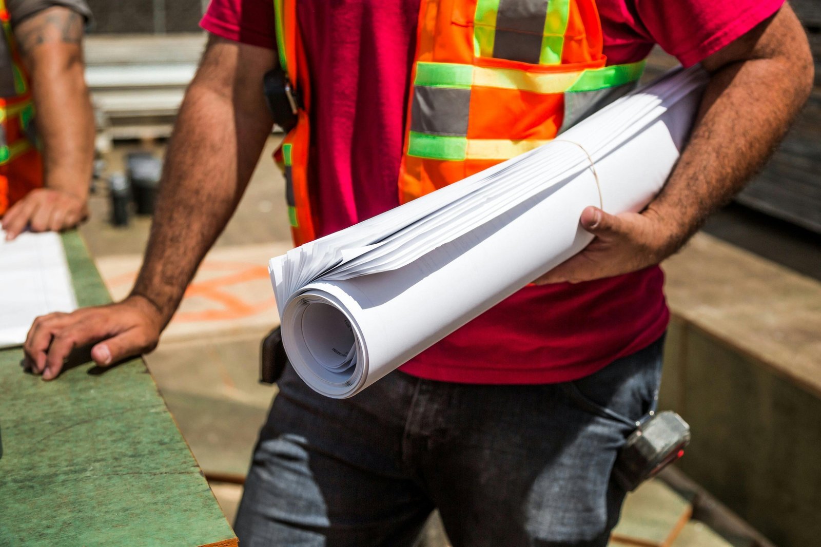 Construction worker carrying architectural plans